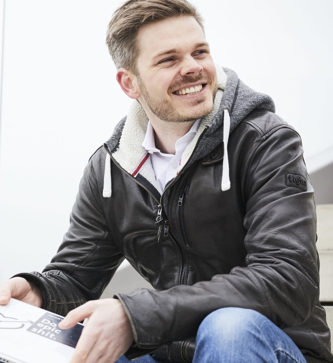 Dr. Jonathan Mall smiling, notebook in hand