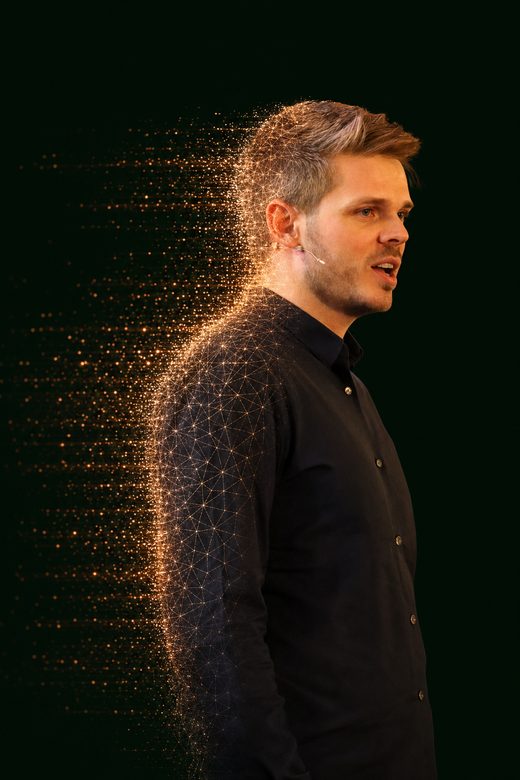 Dr. Jonathan T. Mall in profile, half photorealistic, half dissolving into glowing amber data points: the speaker and his AI-scaled self