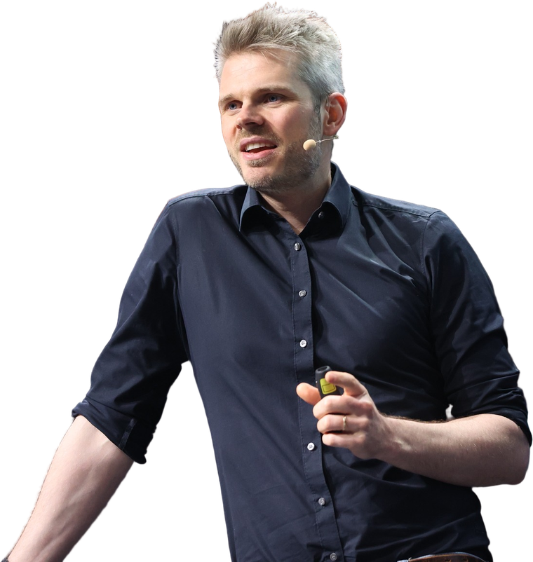 Dr. Jonathan T. Mall, Neuropsychologe und KI-Keynote-Speaker, auf dunkler B&uuml;hne im Scheinwerferlicht